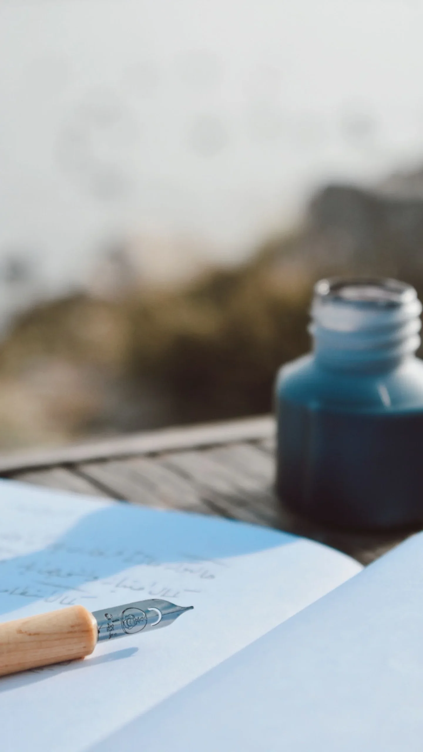 Fountain pen and a bottle of fountain pen ink on a wooden table
